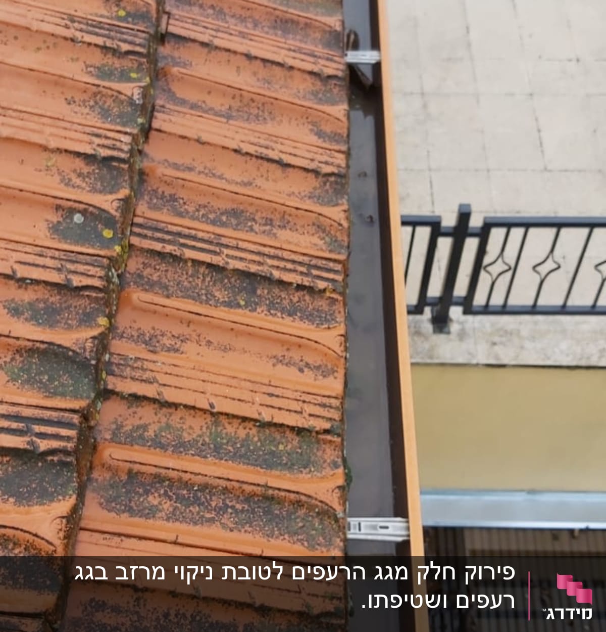 מרזב מתכת ליד גג רעפים אדום